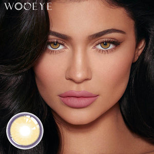 The girl's face is looking straight ahead, the upper left is the Wooeye logo, and the lower left is a close-up of the Grape Brown contact lens