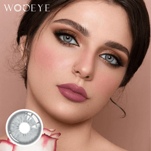 The girl's face is looking straight ahead, the upper left is the Wooeye logo, and the lower left is a close-up of the Casa Gray contact lens