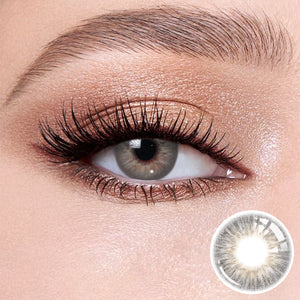 The effect of wearing Omg Gray I Contact Lenses, with a close-up of the product in the lower right corner