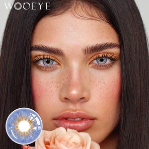 The girl's face is looking straight ahead, the upper left is the Wooeye logo, and the lower left is a close-up of the Vegas Blue contact lens
