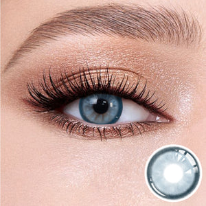 The effect of wearing Mystery Blue Contact Lenses, with a close-up of the product in the lower right corner