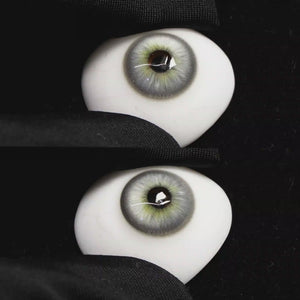 A simulated brown prosthetic eye showing the visual transformation effect of wearing Wooeye Casa Gray colored contact lenses against a black background.