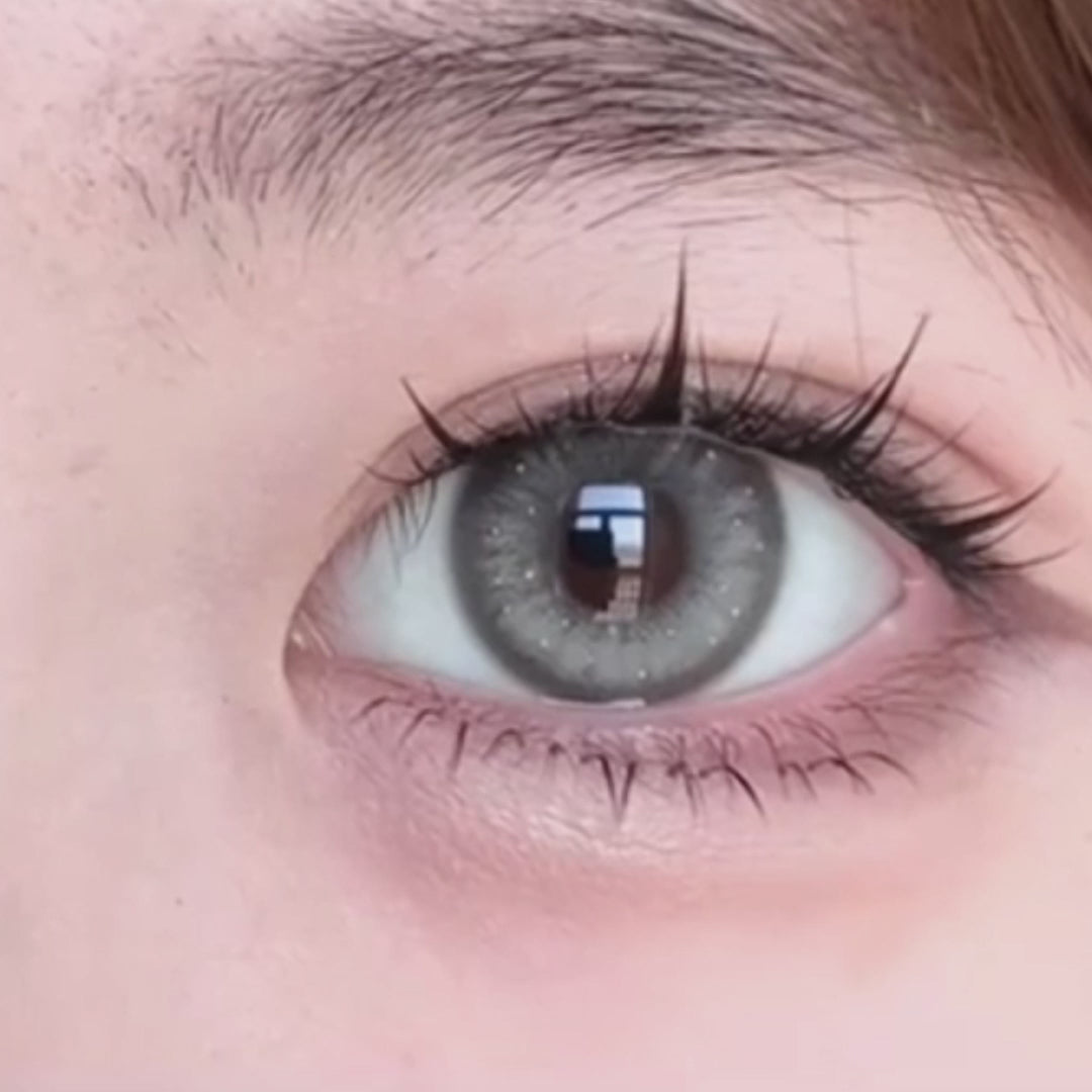 Woman winks while wearing Jennie Grey I contact lenses