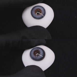 A simulated brown prosthetic eye showing the visual transformation effect of wearing Wooeye Nut Blue colored contact lenses against a black background.