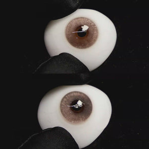 A simulated brown prosthetic eye showing the visual transformation effect of wearing Wooeye Clouds Brown colored contact lenses against a black background.