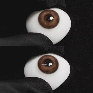A simulated brown prosthetic eye showing the visual transformation effect of wearing Wooeye Nut Brown colored contact lenses against a black background.