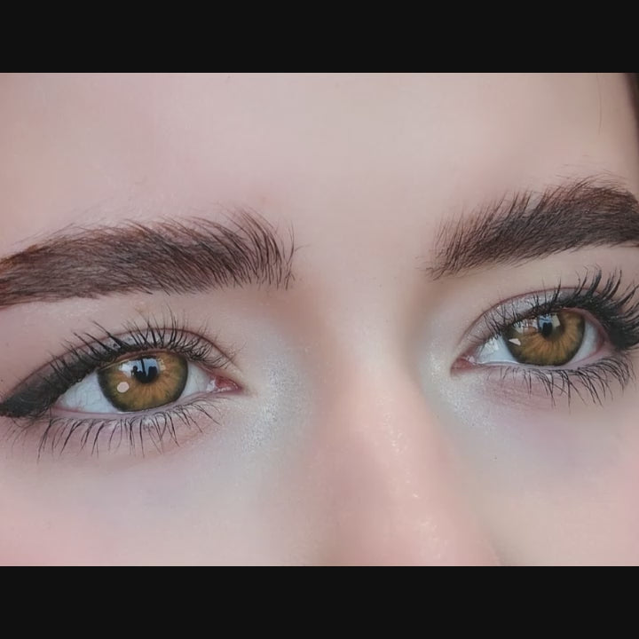 Woman winks while wearing Cleo Hazel Brown contact lenses