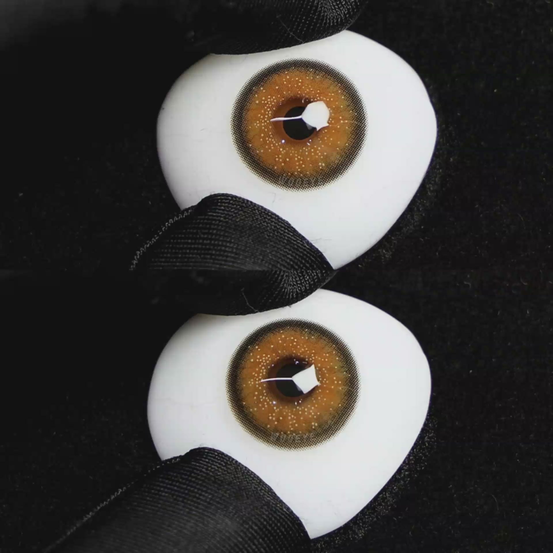 A simulated brown prosthetic eye showing the visual transformation effect of wearing Wooeye Star Brown colored contact lenses against a black background.