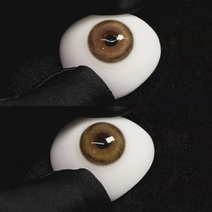 A simulated brown prosthetic eye showing the visual transformation effect of wearing Wooeye Glass Brown colored contact lenses against a black background.