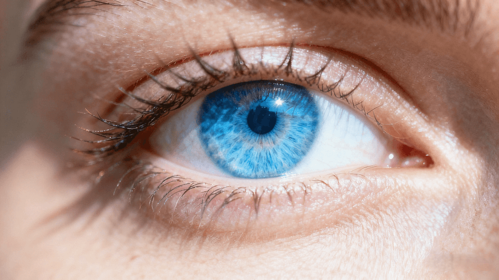 Close-up of a bright blue human eye showing natural beauty, clarity, and calm expression.