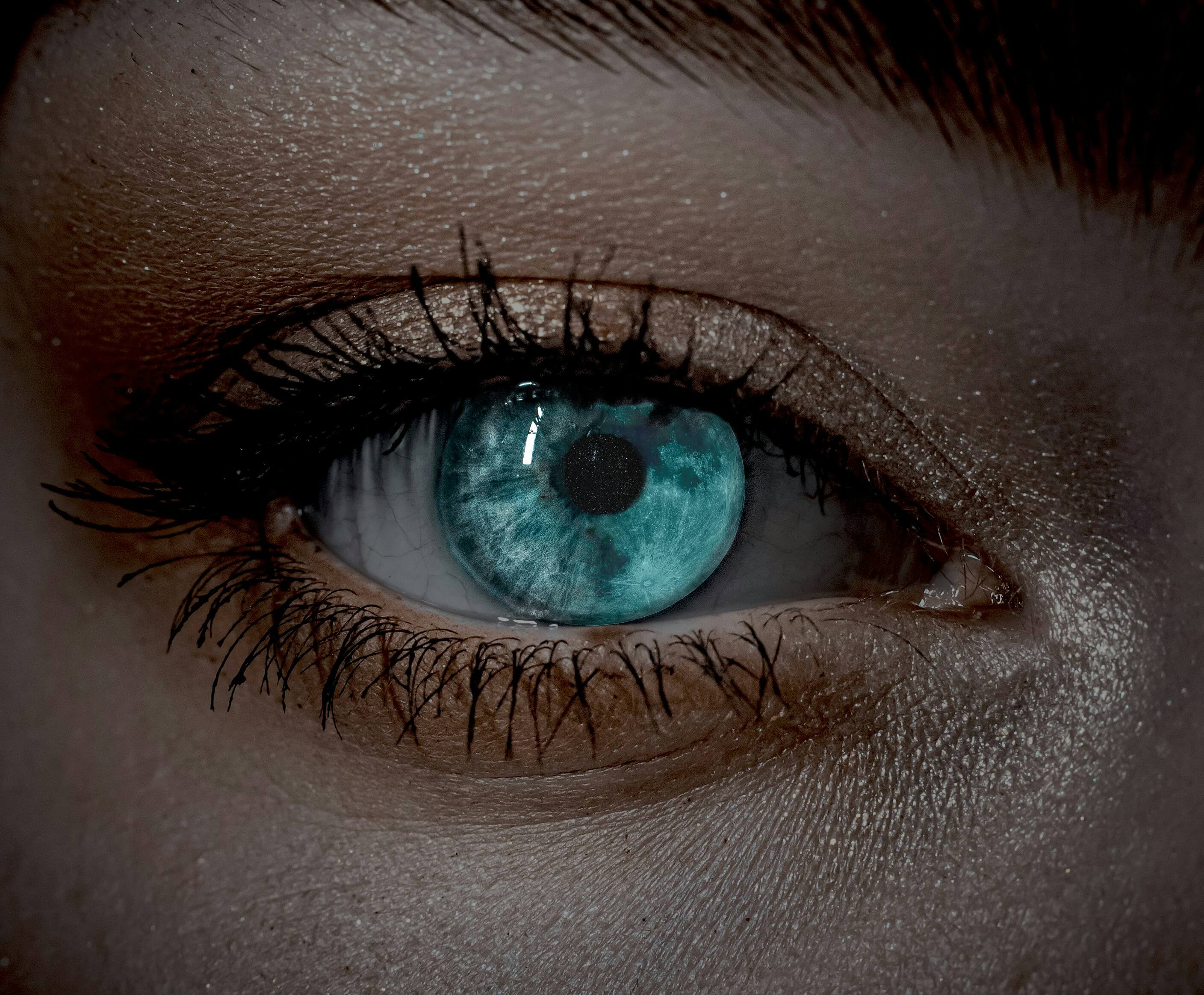 Close-up of a ice blue eyes eye with intricate iris details and long eyelashes.