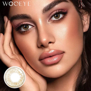 The girl's face is looking straight ahead, the upper left is the Wooeye logo, and the lower left is a close-up of the Delicious Honey Brown contact lens