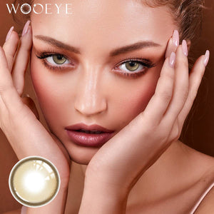 The girl's face is looking straight ahead, the upper left is the Wooeye logo, and the lower left is a close-up of the Acorn Honey Grey contact lens