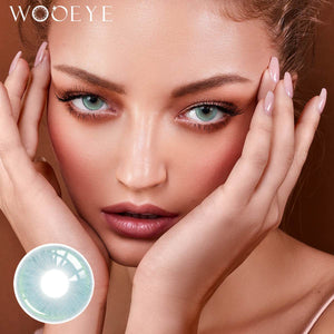The girl's face is looking straight ahead, the upper left is the Wooeye logo, and the lower left is a close-up of the Milk Blue contact lens