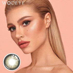 The girl's face is looking straight ahead, the upper left is the Wooeye logo, and the lower left is a close-up of the Acorn Amber Grey contact lens