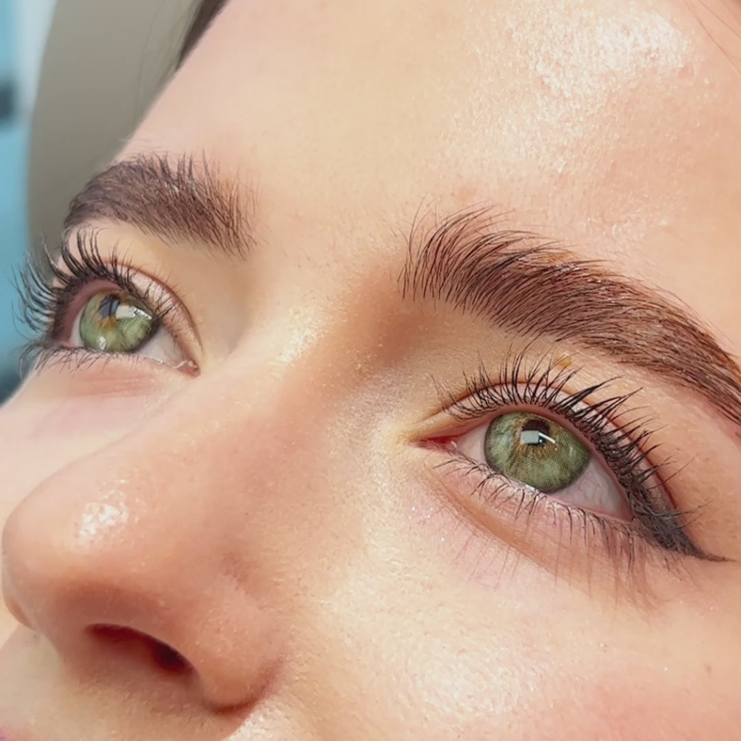 Woman winks while wearing Mermaid Green contact lenses