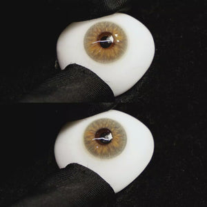A simulated brown prosthetic eye showing the visual transformation effect of wearing Molly Brown Grey colored contact lenses against a black background.