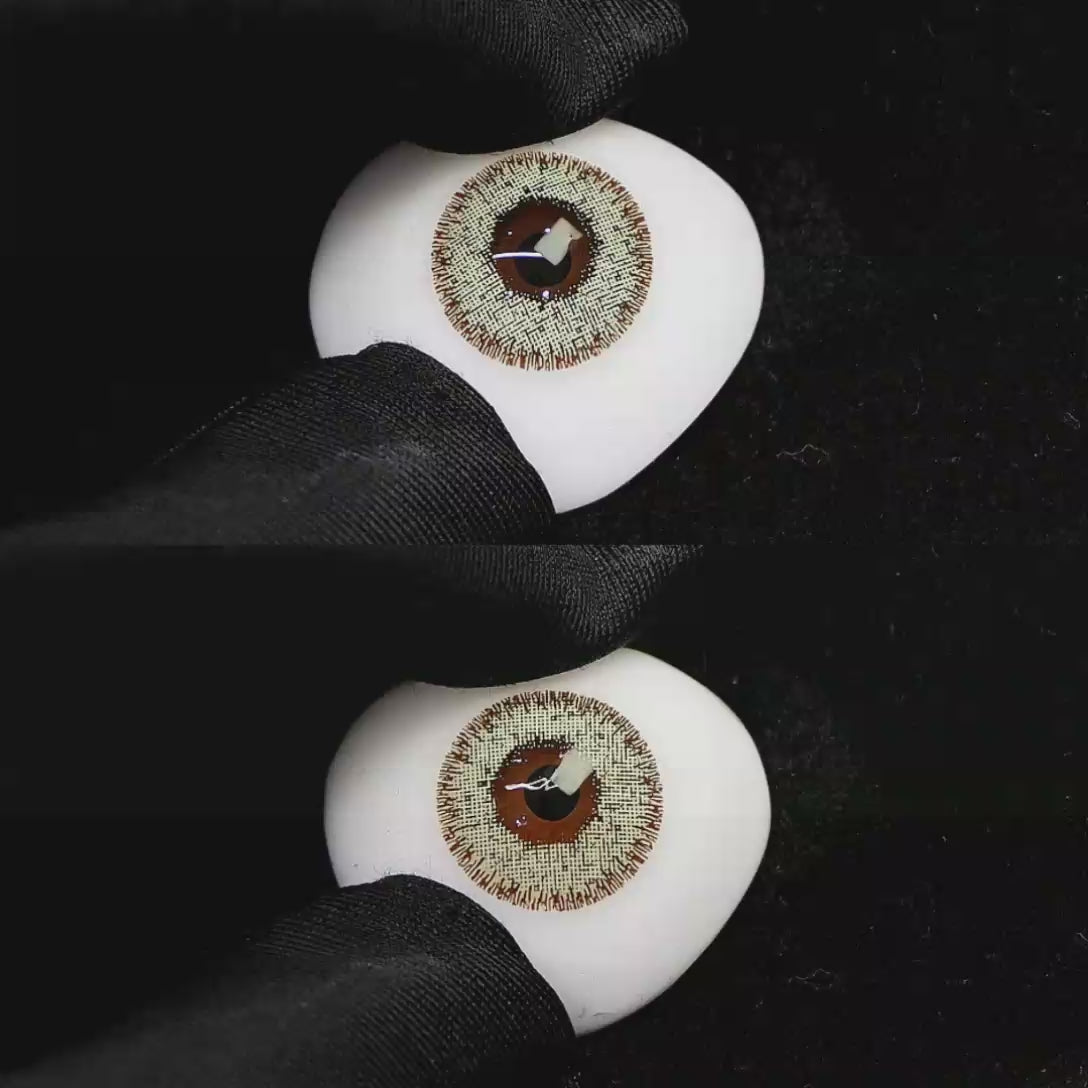 A simulated brown prosthetic eye showing the visual transformation effect of wearing Wooeye Cream Flaxseed Gray colored contact lenses against a black background.