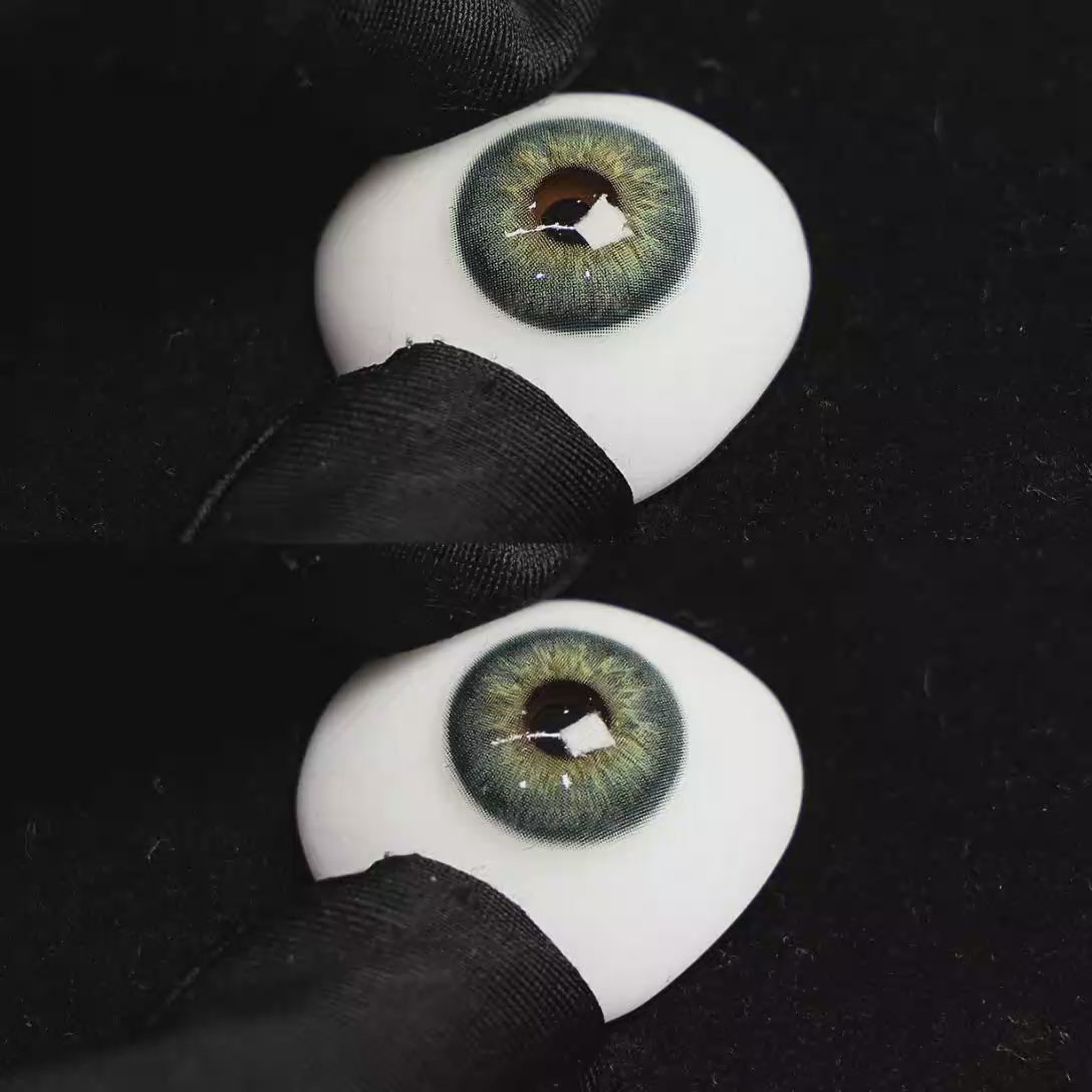 A simulated brown prosthetic eye showing the visual transformation effect of wearing Origin Glow Blue colored contact lenses against a black background.