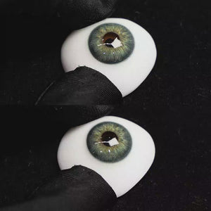 A simulated brown prosthetic eye showing the visual transformation effect of wearing Origin Glow Blue colored contact lenses against a black background.