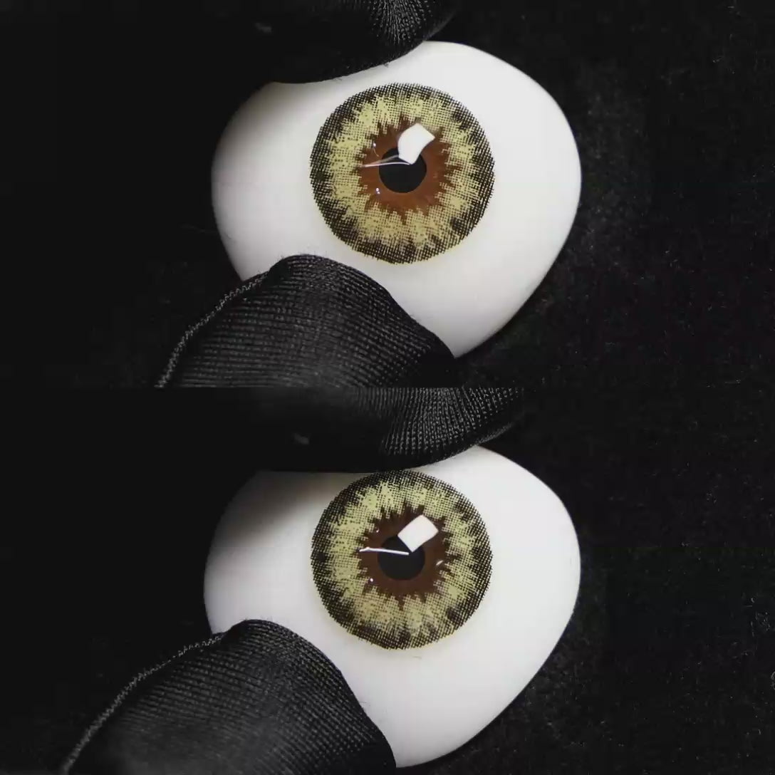 A simulated brown prosthetic eye showing the visual transformation effect of wearing Wooeye Queen Brown I colored contact lenses against a black background.