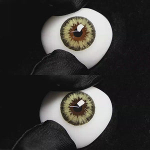 A simulated brown prosthetic eye showing the visual transformation effect of wearing Wooeye Queen Brown I colored contact lenses against a black background.