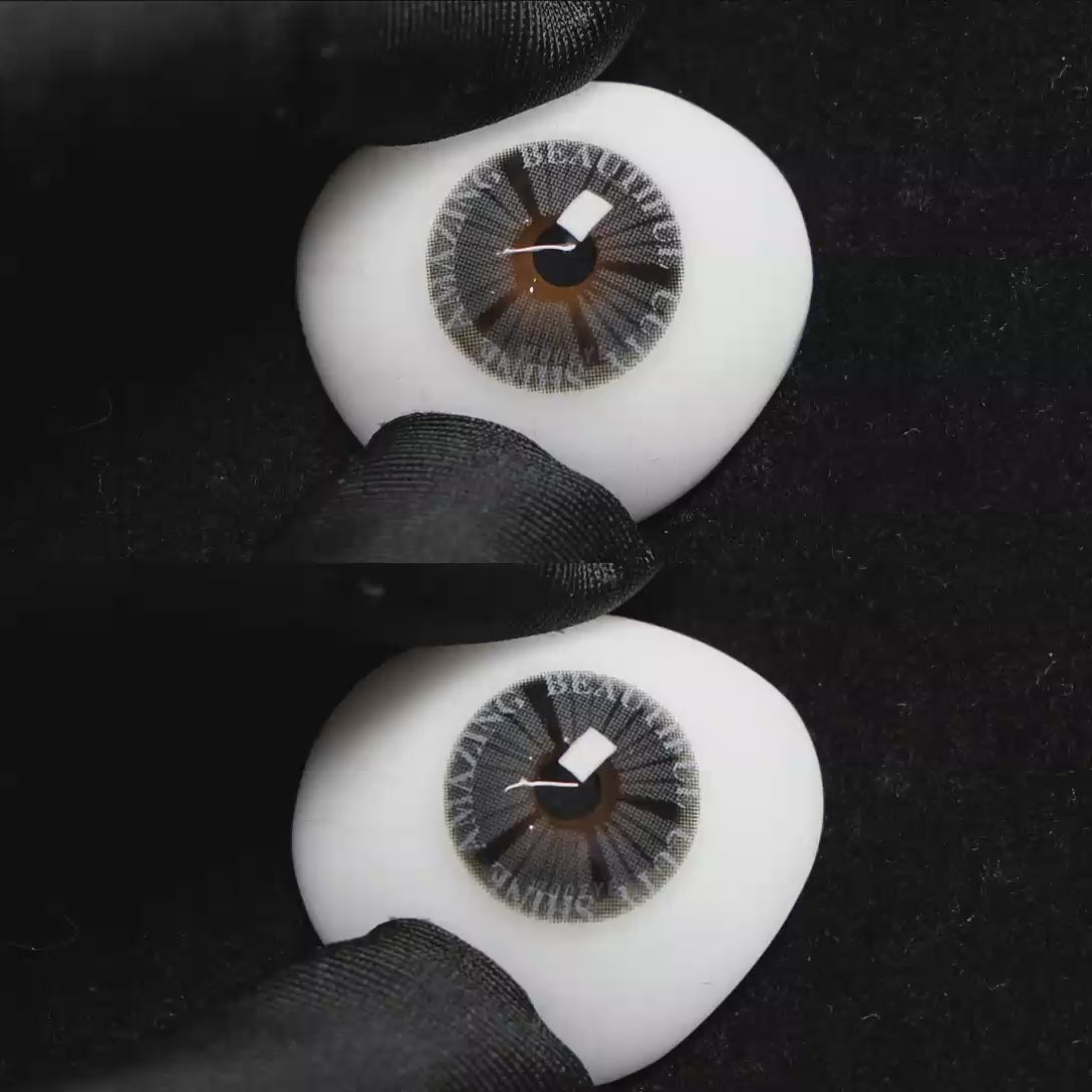 A simulated brown prosthetic eye showing the visual transformation effect of wearing Wooeye Plato Gray colored contact lenses against a black background.