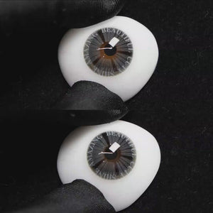 A simulated brown prosthetic eye showing the visual transformation effect of wearing Wooeye Plato Gray colored contact lenses against a black background.
