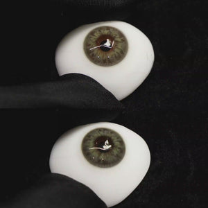 A simulated brown prosthetic eye showing the visual transformation effect of wearing Wooeye Taylor Green colored contact lenses against a black background.