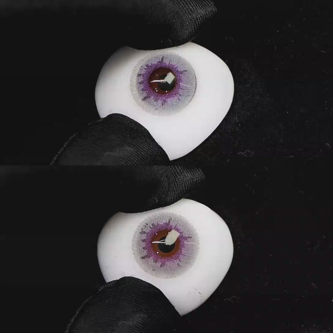 A simulated brown prosthetic eye showing the visual transformation effect of wearing Wooeye Cream Salty purple colored contact lenses against a black background.