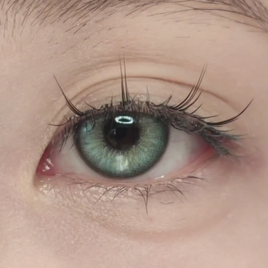 Woman winks while wearing Diamond Green II contact lenses