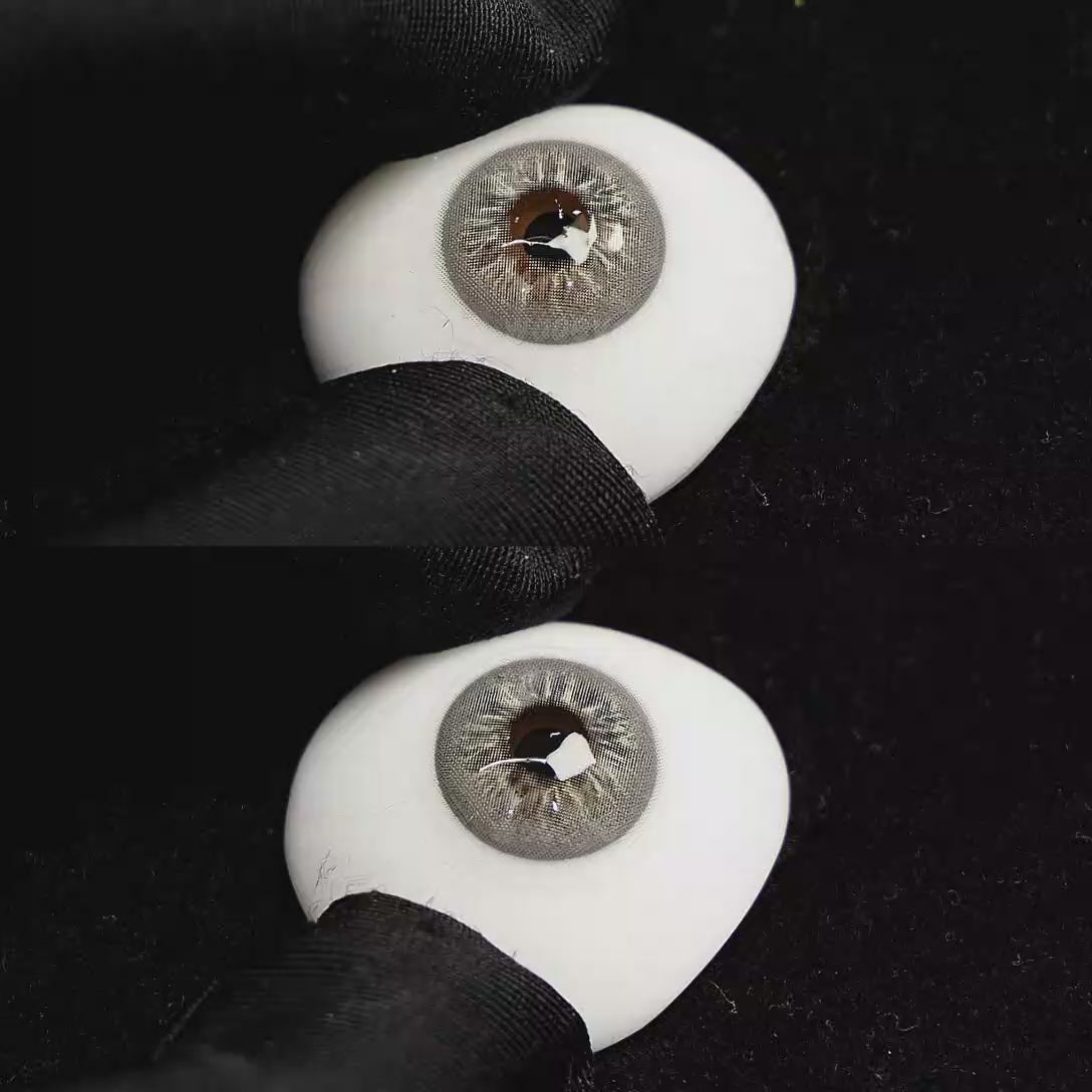 A simulated brown prosthetic eye showing the visual transformation effect of wearing Cape Cod Grey colored contact lenses against a black background.