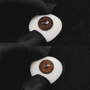 A simulated brown prosthetic eye showing the visual transformation effect of wearing hazel brown colored contact lenses against a black background.