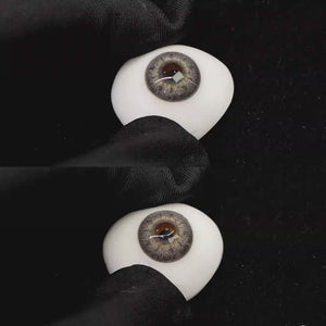 A simulated brown prosthetic eye showing the visual transformation effect of wearing banshe gray colored contact lenses against a black background.