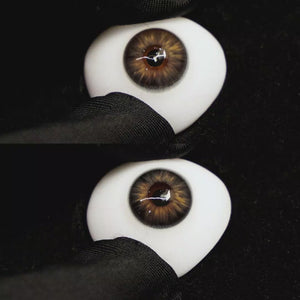 A simulated brown prosthetic eye showing the visual transformation effect of wearing molly brown black colored contact lenses against a black background.
