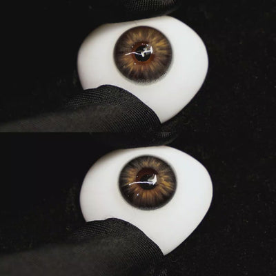 A simulated brown prosthetic eye showing the visual transformation effect of wearing molly brown black colored contact lenses against a black background.