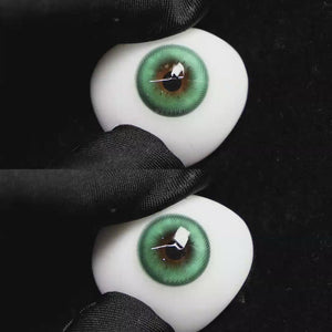 A simulated brown prosthetic eye showing the visual transformation effect of wearing Wooeye Romantic Green colored contact lenses against a black background.