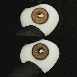 A simulated brown prosthetic eye showing the visual transformation effect of wearing Grape Brown colored contact lenses against a black background.
