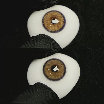 A simulated brown prosthetic eye showing the visual transformation effect of wearing Grape Brown colored contact lenses against a black background.