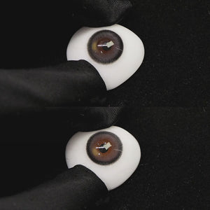 A simulated brown prosthetic eye showing the visual transformation effect of wearing misty gray colored contact lenses against a black background.