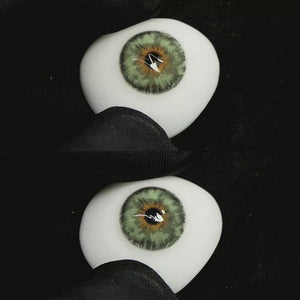 A simulated brown prosthetic eye showing the visual transformation effect of wearing Mermaid Green colored contact lenses against a black background.