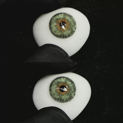 A simulated brown prosthetic eye showing the visual transformation effect of wearing Mermaid Green colored contact lenses against a black background.