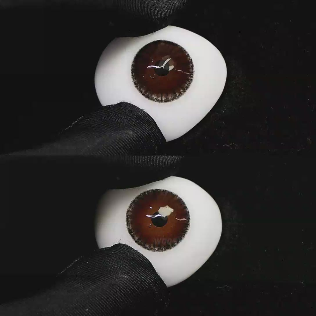 A simulated brown prosthetic eye showing the visual transformation effect of wearing Wooeye Moon Brown I colored contact lenses against a black background.