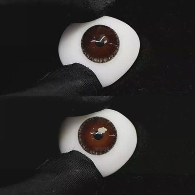 A simulated brown prosthetic eye showing the visual transformation effect of wearing Wooeye Moon Brown I colored contact lenses against a black background.