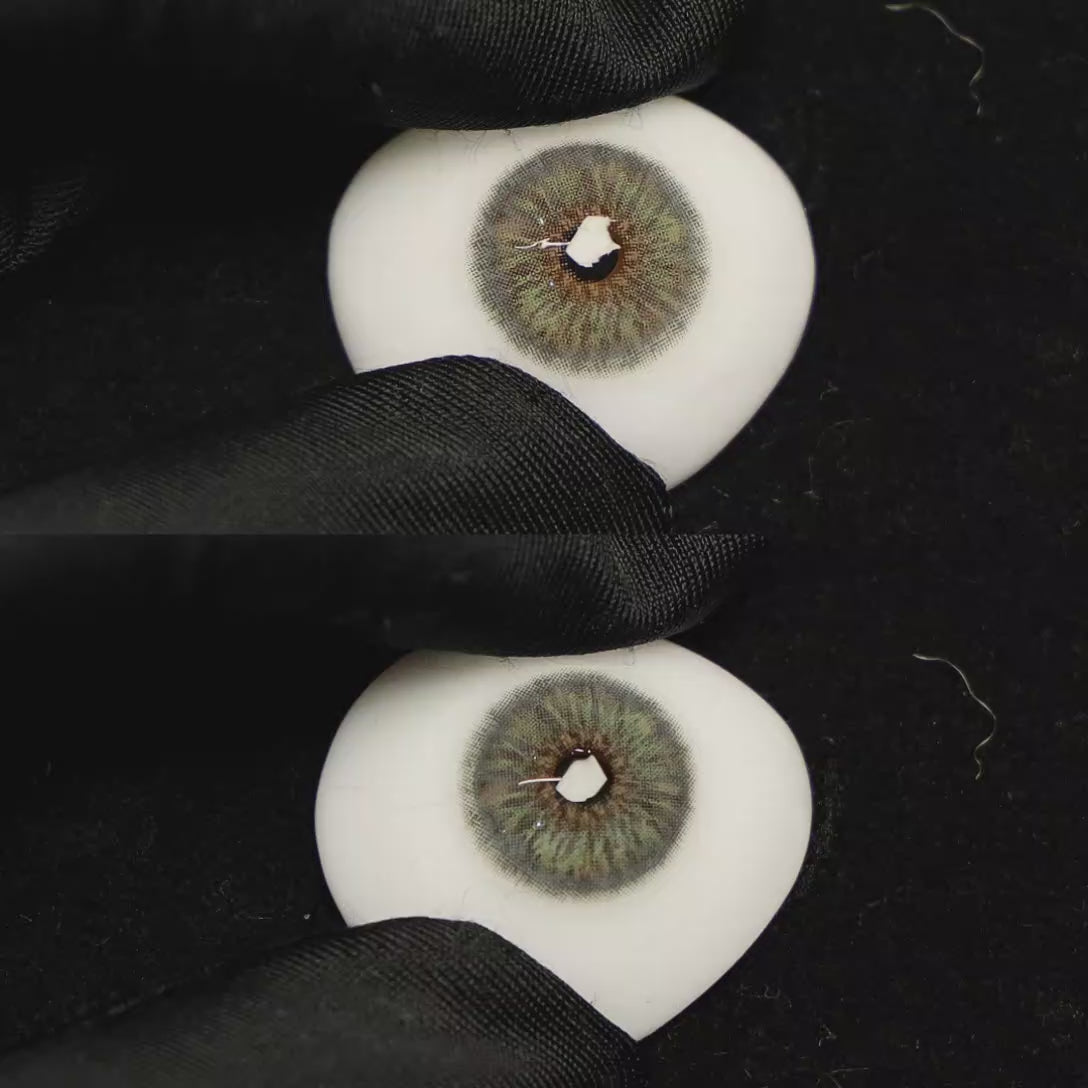 A simulated brown prosthetic eye showing the visual transformation effect of wearing Breeze Grey colored contact lenses against a black background.