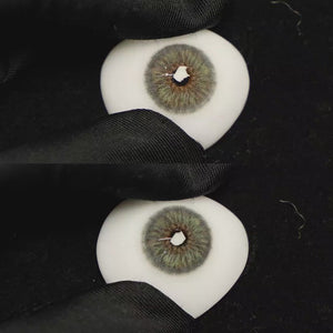 A simulated brown prosthetic eye showing the visual transformation effect of wearing Breeze Grey colored contact lenses against a black background.