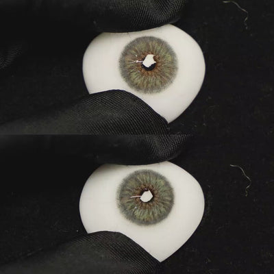 A simulated brown prosthetic eye showing the visual transformation effect of wearing Breeze Grey colored contact lenses against a black background.