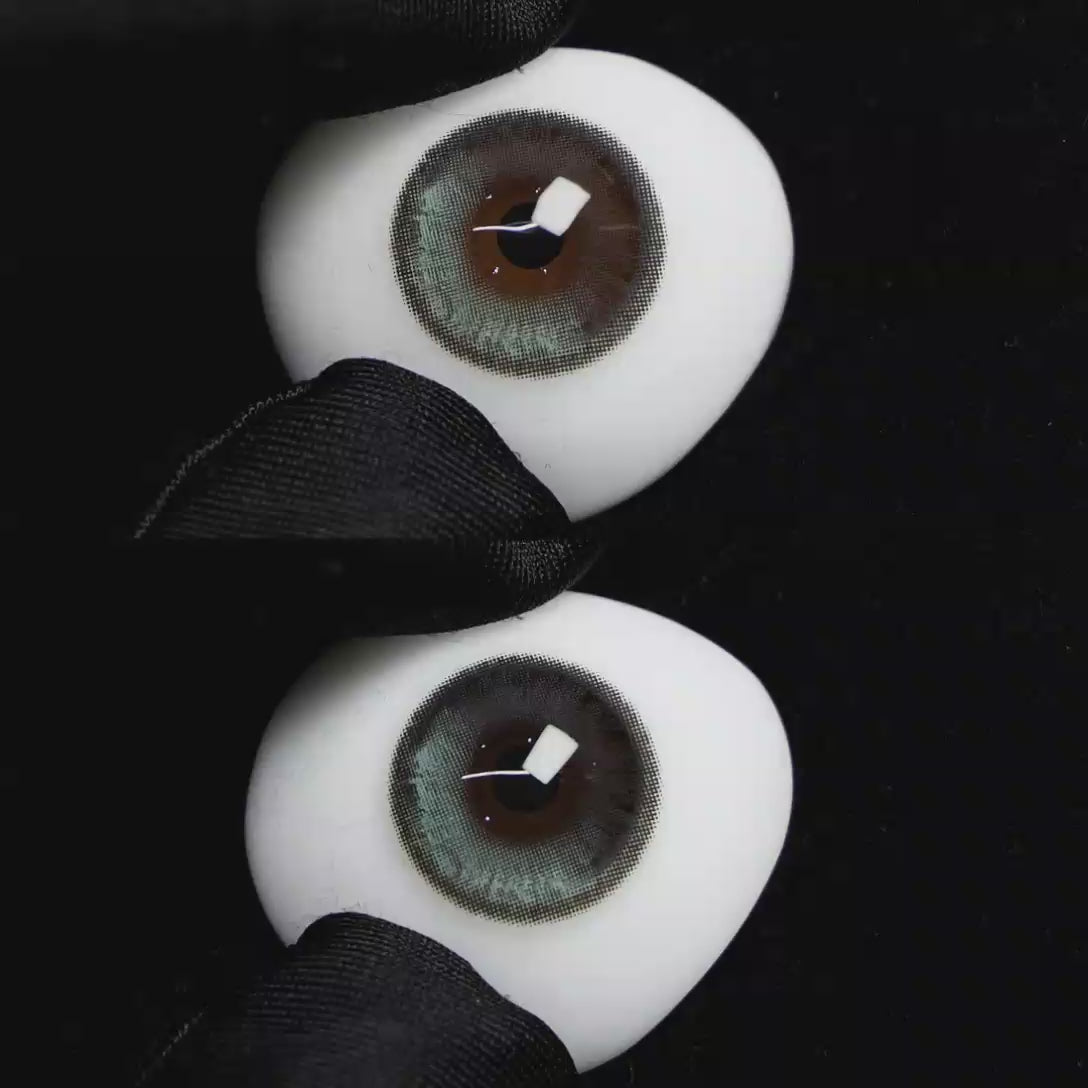 A simulated brown prosthetic eye showing the visual transformation effect of wearing Wooeye Bubbles Gray colored contact lenses against a black background.