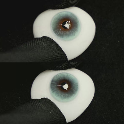 A simulated brown prosthetic eye showing the visual transformation effect of wearing Milk Blue colored contact lenses against a black background.