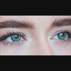 Woman winks while wearing Star Green contact lenses